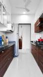 Cuisine couloir en bois sombre et plan de travail noir - Batignolles Paris