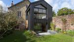 Extension en zinc vitrée sur maison en pierres