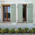 Volets PVC finition vert tilleul sur encadrement fenêtre finition bois chaud