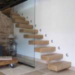 escalier suspendu bois clair accolé mur