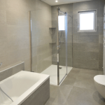 salle de bain rénovée avec baignoire et douche