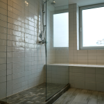 Douche moderne avec carrelage blanc et paroi vitrée minimaliste