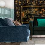 Canapé velours bleu nuit et coussin émeraude dans un salon
