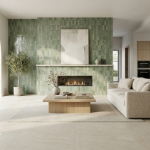 Salon moderne avec mur en carrelage vert type zellige autour d’une cheminée, grande baie vitrée et carrelage grand format au sol.