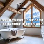 Salle de bain aménagée sous les combles avec poutres apparentes, baignoire îlot et vue sur les montagnes en Haute-Savoie – conseils d’aménagement.