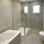salle de bain rénovée avec baignoire et douche
