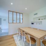 La chaleur du bois et la pureté du blanc dans cette salle à manger