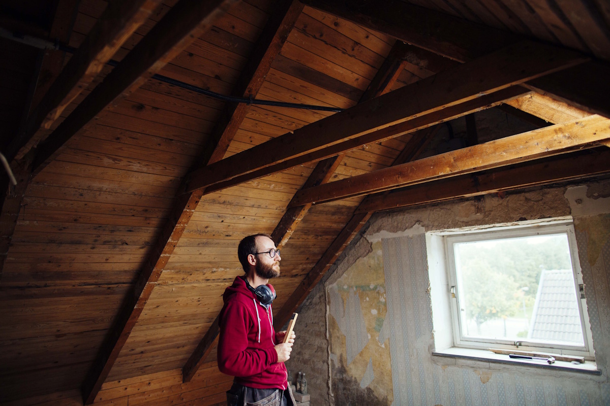 Professionnel cherchant de possibles fuites sous la toiture